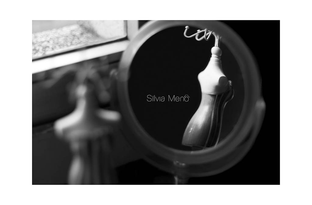 Un espejo circular y se refleja una figura de maniquí pequeña.