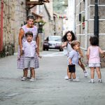 Una señora y cuatro niños en la calle jugando.