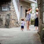 Dos señoras hablando con un niño muy pequeño al lado en la calle.